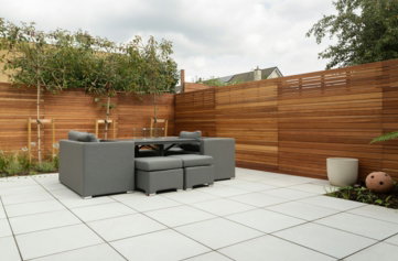 a patio with a couch and a table and chairs