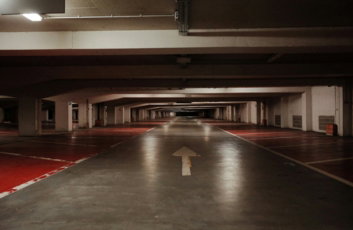 an empty parking garage with a red floor